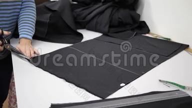纺织品，工人在白色桌子上切割黑色织物